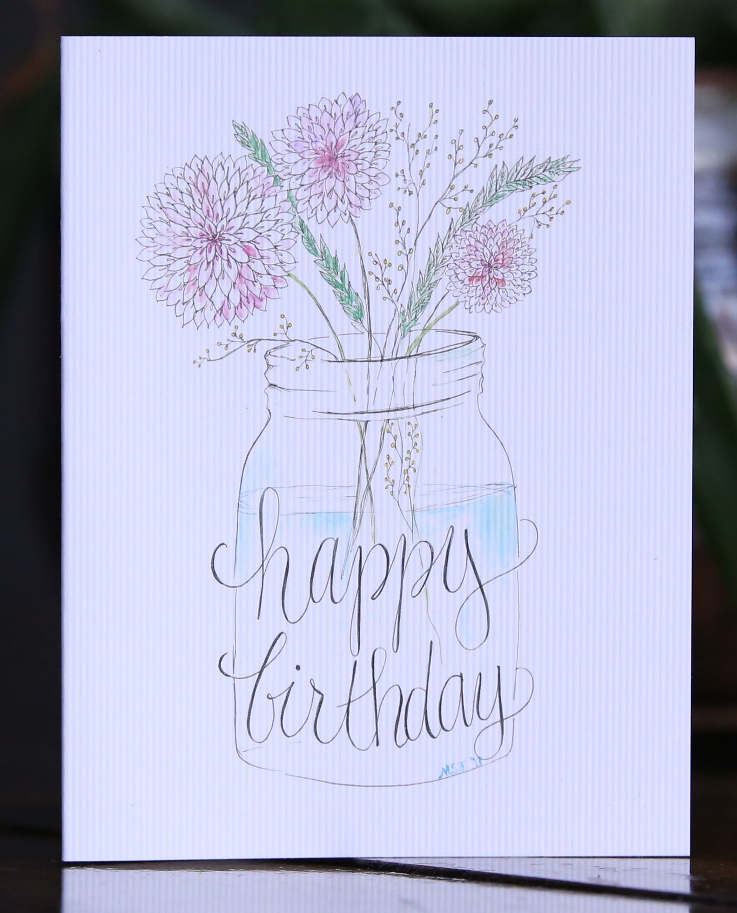 A mason jar filled with wildflowers. Happy Birthday... to you!